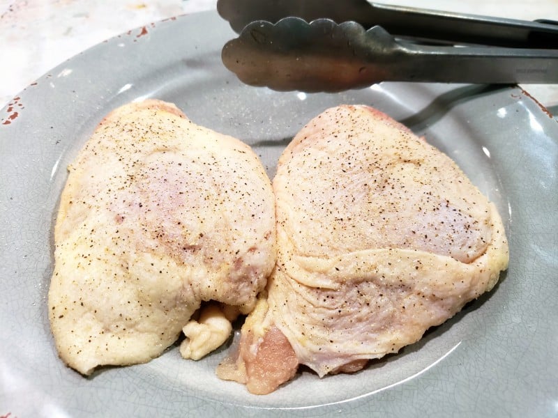 two seasoned chicken thighs on a plate