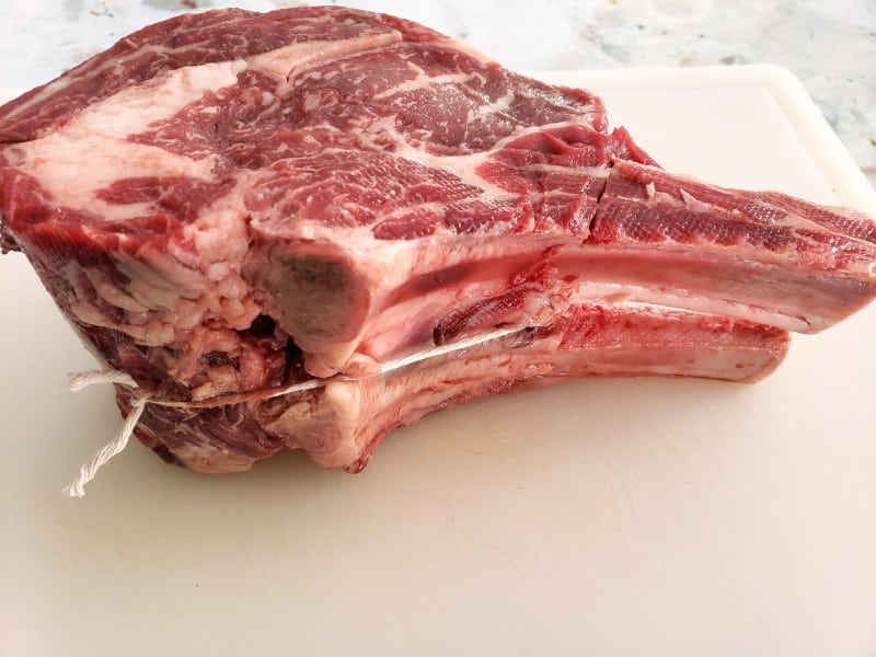 a raw standing rib roast tied with kitchen twine