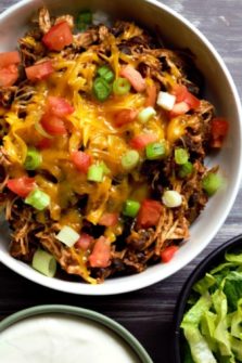 Slow Cooker Chicken Taco Bowl with sides of lettuce and sour cream.