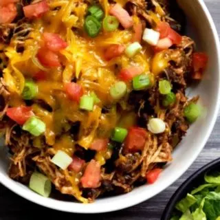 Slow Cooker Chicken Taco Bowl with sides of lettuce and sour cream.