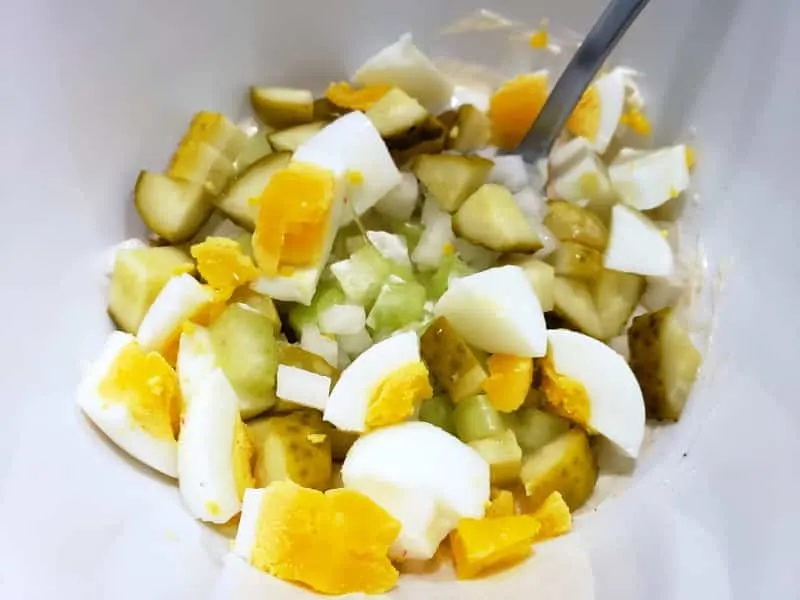 diced onion, celery, hardboiled egg, and pickles in a bowl