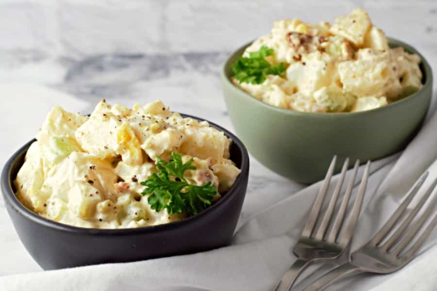 two bowls of loaded small batch potato salad and two forks