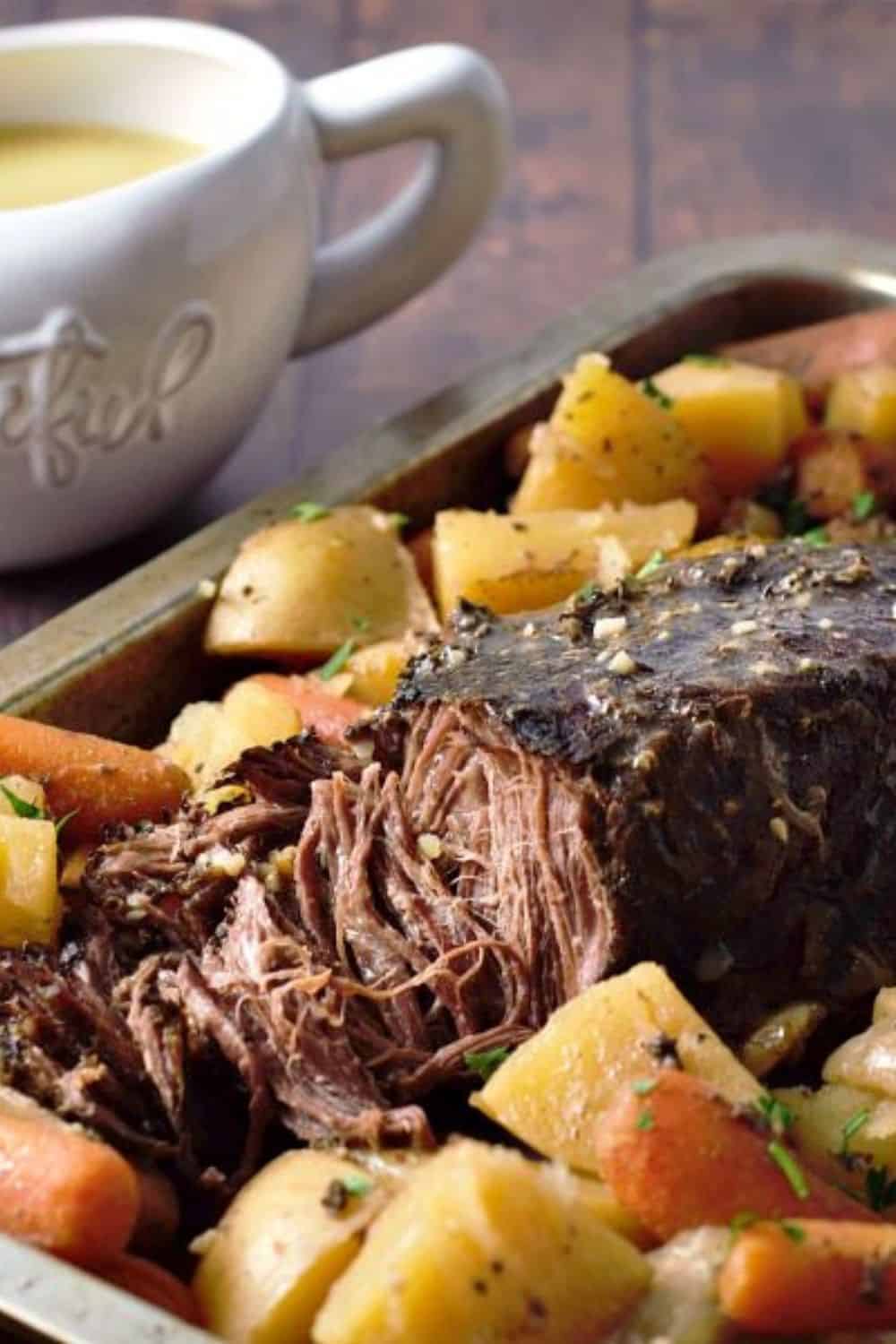 Slow Cooker Pot Roast Dinner on a tray with a side of gravy.