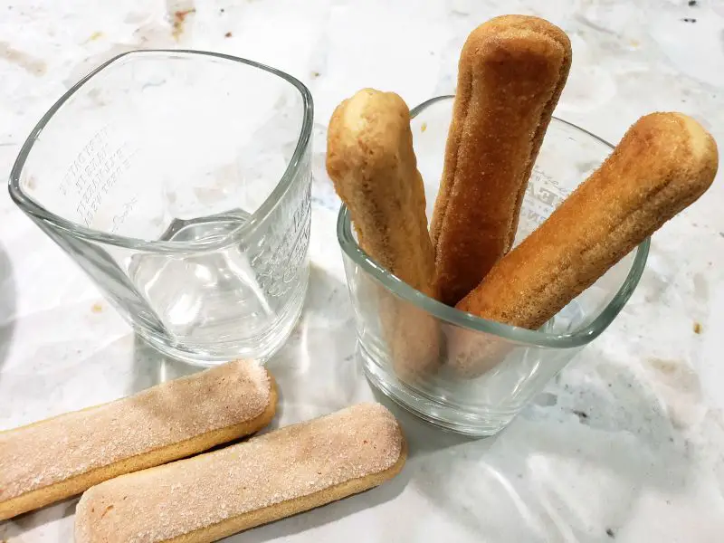 ladyfinger biscuits standing vertical in a whiskey glass