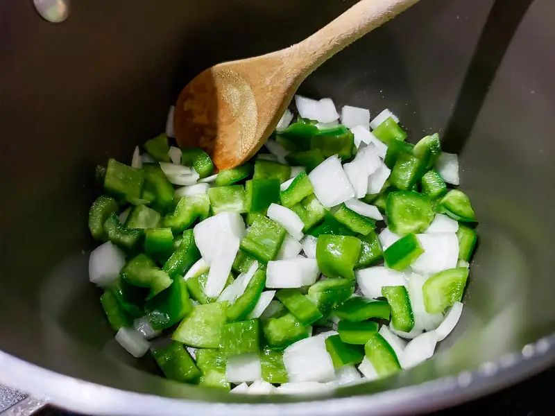 onions and green pepper chunks in a sauce pan