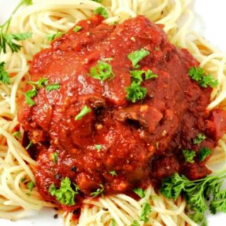 Slow Cooker Chicken Cacciatore over spaghetti on a plate.