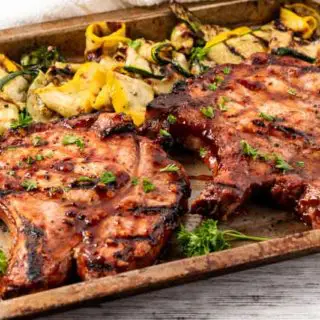 grilled zucchini and honey garlic pork chops on a tray