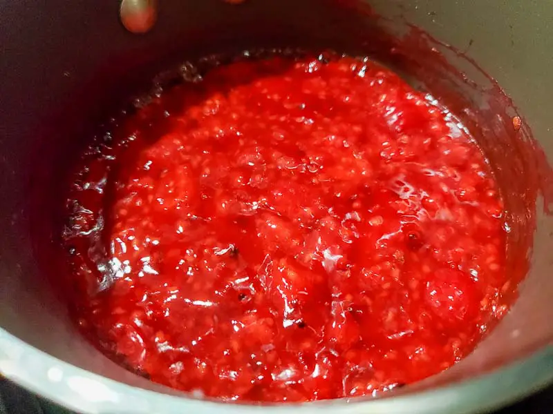 raspberry sauce cooking in a pan.