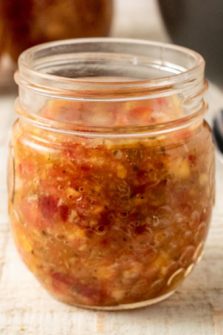 Tomato Peach Salsa in a small jar.