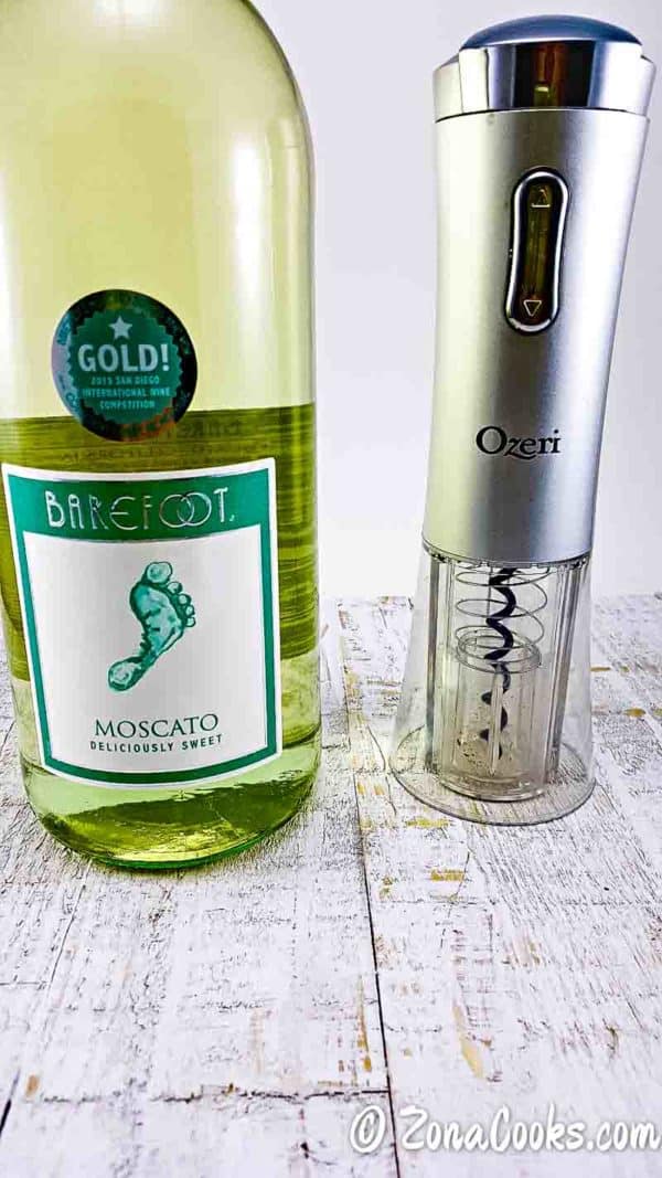 a bottle of moscato and an electric wine opener.