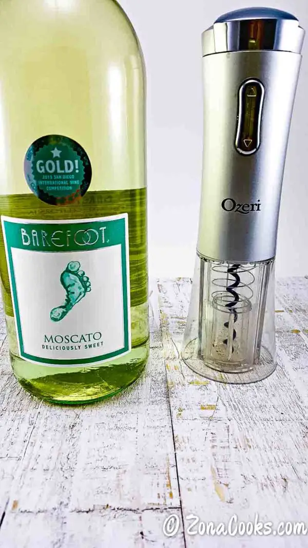 a bottle of moscato and an electric wine opener.