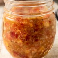 Tomato Peach Salsa in a small jar.