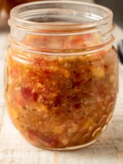 Tomato Peach Salsa in a small jar.