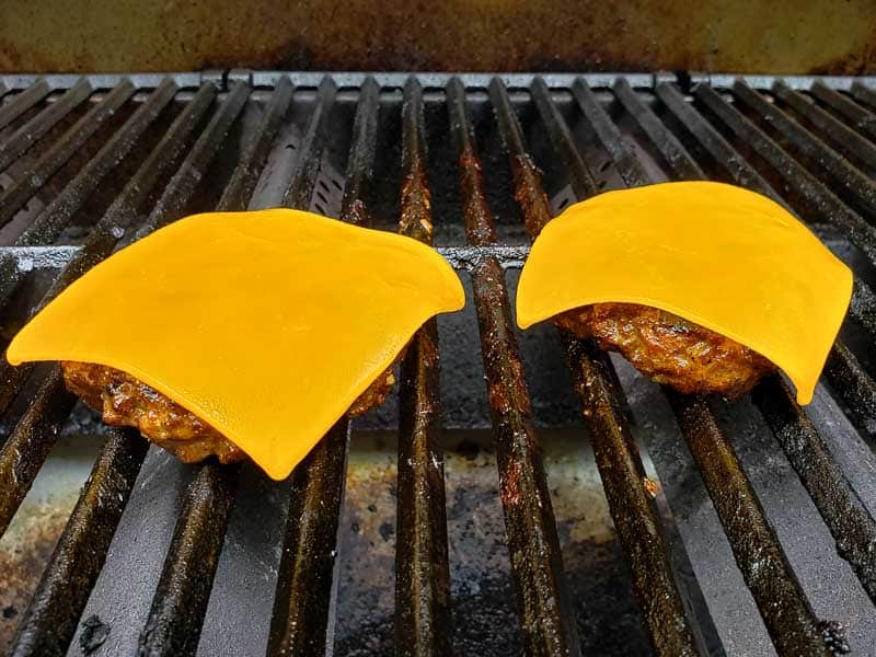 cheddar cheese on top of two hamburgers