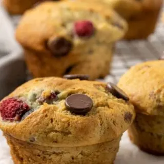 5 Raspberry Dark Chocolate Banana Bread Muffins on a plate and a wire rack.