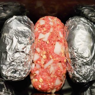 meatloaf and tin foil wrapped potatoes in a crockpot.