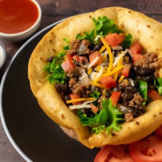 a taco salad with sour cream and dressing