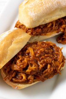 two Zesty Crockpot Shredded BBQ Chicken Sandwiches on a platter.