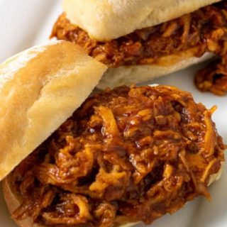 two Zesty Crockpot Shredded BBQ Chicken Sandwiches on a platter.