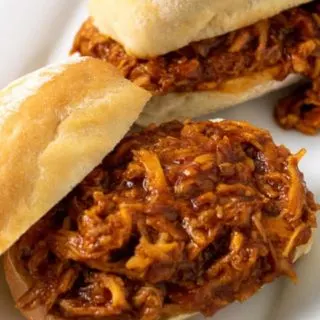 two Zesty Crockpot Shredded BBQ Chicken Sandwiches on a platter.