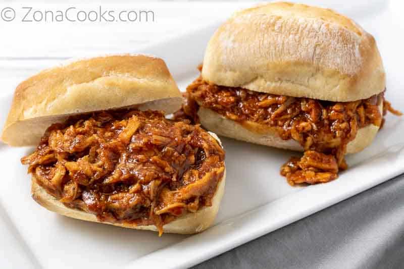 two sandwiches with zesty bbq shredded chicken on them