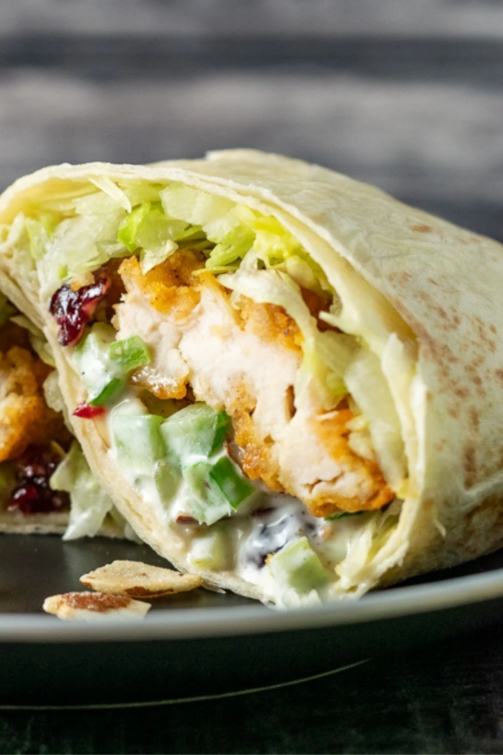 a crispy chicken wrap cut open on a plate.
