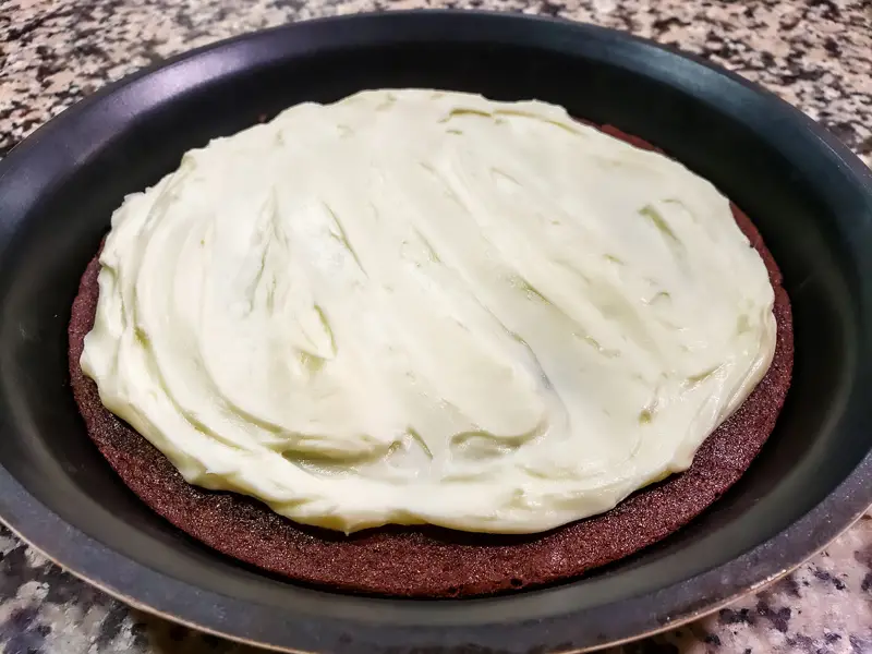 cream cheese mixture spread over baked brownie pizza layer