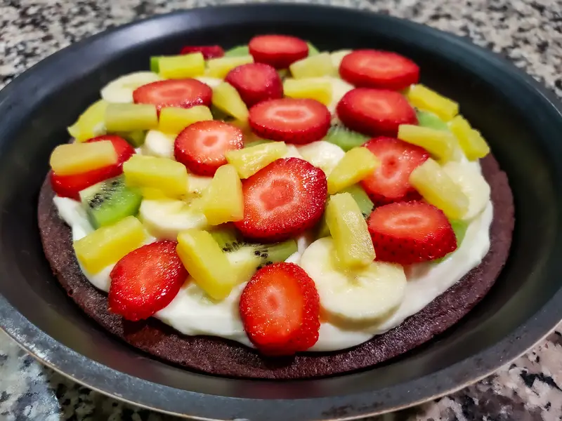 strawberries, kiwi, pineapple, and banana layered over cream cheese and brownie pizza