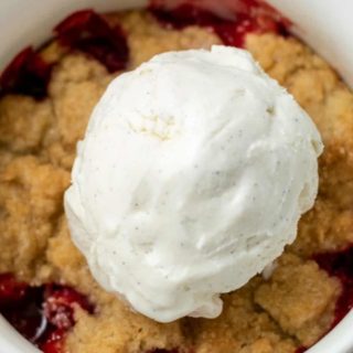 Cakey Strawberry Cobbler topped with vanilla bean ice cream.