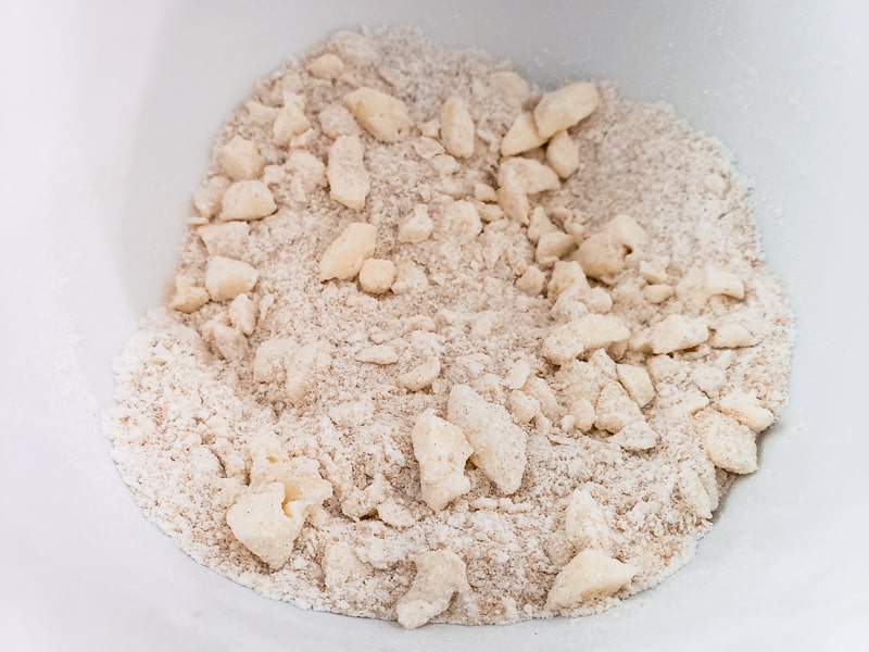 flour, sugar, bown sugar, baking powder, salt, and butter mixed in a bowl
