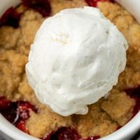 Cakey Strawberry Cobbler topped with vanilla bean ice cream.