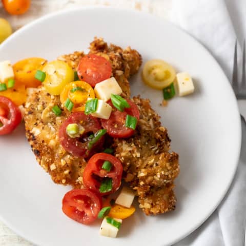 Almond Crusted Chicken with Italian Tomato Salad on a plate
