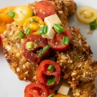 Almond Panko Chicken with Italian Tomato Salad on a plate.