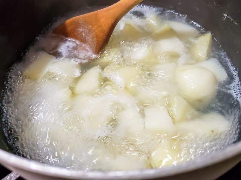 potatoes boiling in a sauce pan.