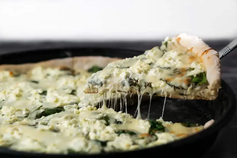 Goat Cheese and Pizza with a slice being lifted up.