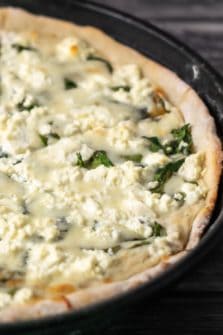 Goat Cheese and Spinach Pizza in a pizza pan.