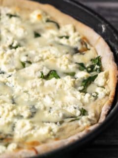 Goat Cheese and Spinach Pizza in a pizza pan.