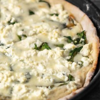 Goat Cheese and Spinach Pizza in a pizza pan.