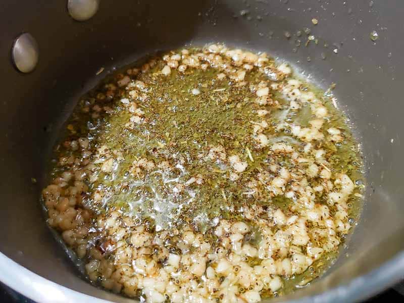 Italian seasoning, salt, pepper, garlic and olive oil cooking in a pan