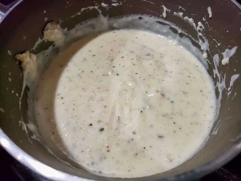 white garlic sauce cooking in a pan