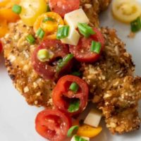 Almond Panko Chicken with Italian Tomato Salad on a plate.