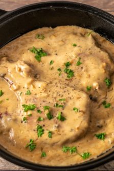 One Skillet Pork Chops and Apple Cider Gravy in a cast iron skillet.