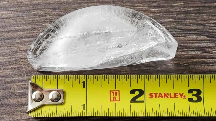 a 2 1/2 inch crescent shaped ice cube and measuring tape