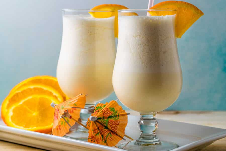 two orange cream slushes in a platter with orange slices
