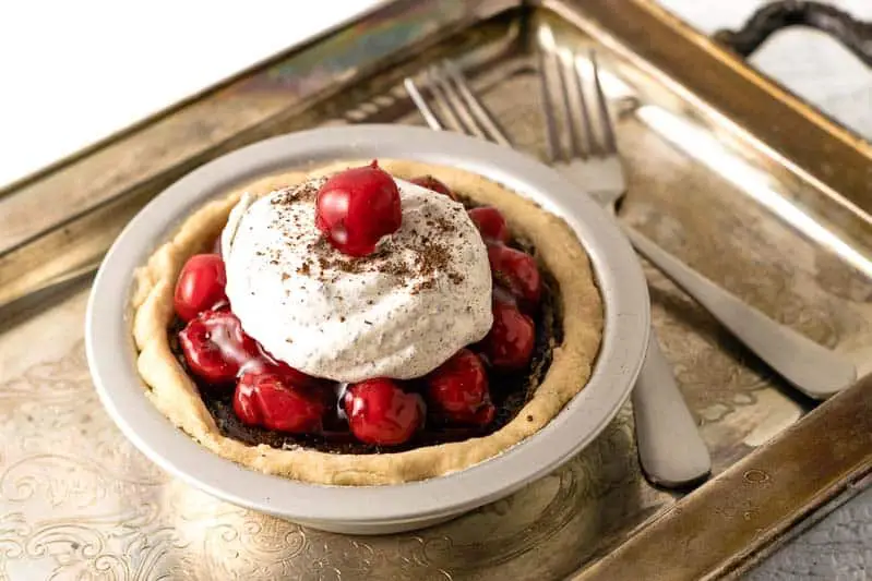 black forest pie on a tarnished tray with two forks.