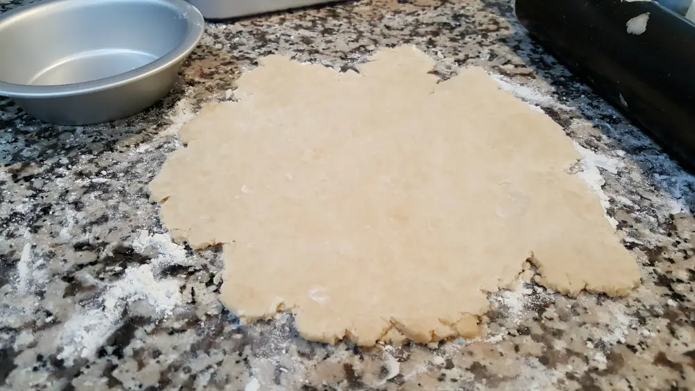 pie crust dough rolled out on a floured surface.
