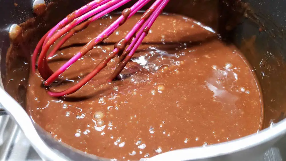 egg mixture whisked into rest of the black forest pie filling cooking in a pan.