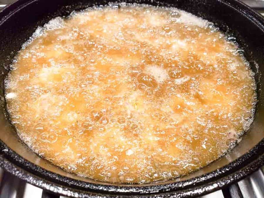 breaded steak cubes frying in a skillet