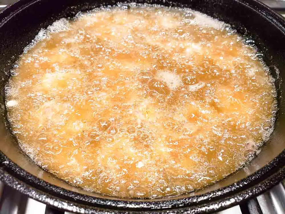 Deep Fried Steak Bites frying in a skillet.