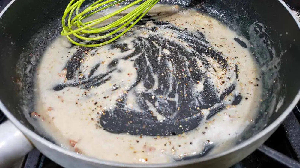 the beginning of Country Gravy from Scratch whisked in a pan.